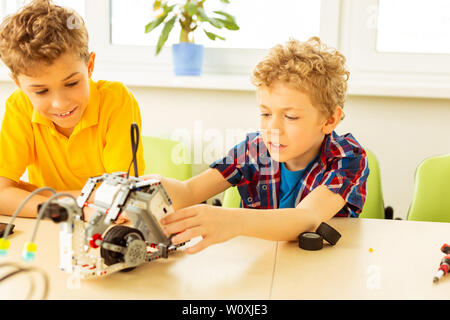 Science engineering. Nice interested boys working on the project while being interested in science Stock Photo