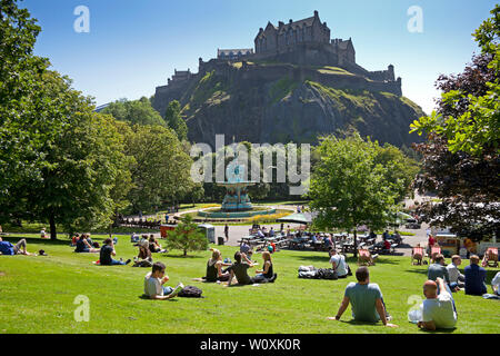 Princes Street Gardens  Edinburgh, Scotland. 28th June 2019. Full sunshine in the city being enjoyed by office workers and visitors, 14 degrees in the morning with cool  wind increasing to 17 degrees in the afternoon allowing a relaxing lunch hour sunbathe. Stock Photo