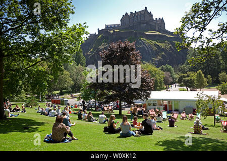 Princes Street Gardens Edinburgh, Scotland. 28th June 2019. Full sunshine in the city being enjoyed by office workers and visitors, 14 degrees in the morning with cool  wind increasing to 17 degrees in the afternoon allowing a relaxing lunch hour sunbathe. Stock Photo