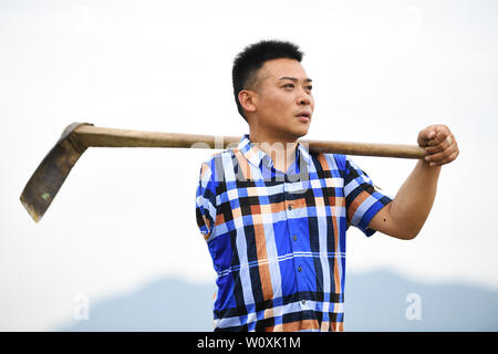 (190628) -- CHONGQING, June 28, 2019 (Xinhua) -- Liu Yi works at a pepper planting base in Yulong Village of Nanping Township in Nanchuan District, southwest China's Chongqing, June 27, 2019. Despite losing his right arm in an accident at the age of nine, 44-year-old Liu Yi has never lowered his head towards destiny. After graduation from a vocational school in 1994, he tried a good many jobs like dishwasher, fruit dealer and coal miner. Since 2010, he has decided to start up his own business at his hometown by organizing villagers to plant bamboo roots and raising chickens. His efforts paid o Stock Photo