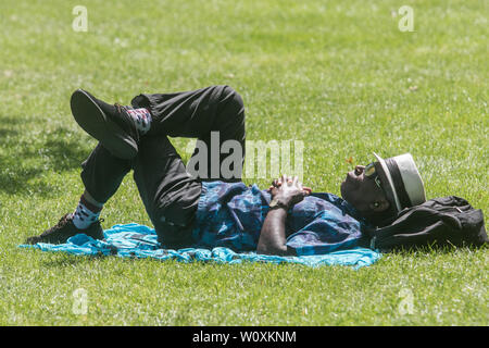 London UK. 28th June 2019. People sunbathing in Green Park on a hot day in London as warm temperatures sweep from Continental Europe  as European capital cities  experience a heatwave and high  record weather for this time of the year  Credit: amer ghazzal/Alamy Live News Stock Photo