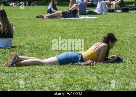 London UK. 28th June 2019. People sunbathing in Green Park on a hot day in London as warm temperatures sweep from Continental Europe  as European capital cities  experience a heatwave and high  record weather for this time of the year  Credit: amer ghazzal/Alamy Live News Stock Photo