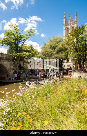 Magdalen bridge and tower are the backdrop for people hiring boats and punts on the river Cherwell on a beautiful sunny afternoon in Oxford. Stock Photo