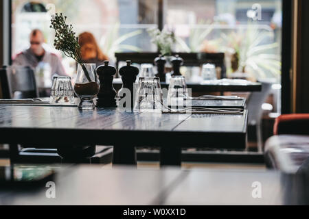 Table set inside a restaurant, selective focus, natural light, windows on the background. Stock Photo