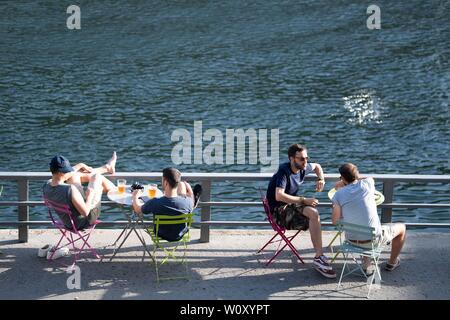 Paris, France. 27th June, 2019. People rest at the riverside of Seine in Paris, France, June 27, 2019. The national weather center, Meteo France, on Thursday warned of 'exceptional heat peak' on June 28, placing 4 southern regions on red alert, the highest alert on the agency's four-scale system, and urges residents to be extremely vigilant. While 76 other regions, except Brittany, in northwest France, remain on orange alert till next week. Credit: Jack Chan/Xinhua/Alamy Live News Stock Photo