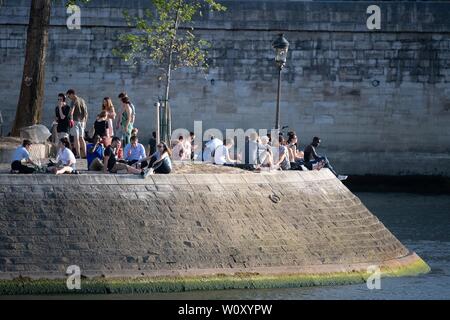 Paris, France. 27th June, 2019. People rest near the Seine river in Paris, France, June 27, 2019. The national weather center, Meteo France, on Thursday warned of 'exceptional heat peak' on June 28, placing 4 southern regions on red alert, the highest alert on the agency's four-scale system, and urges residents to be extremely vigilant. While 76 other regions, except Brittany, in northwest France, remain on orange alert till next week. Credit: Jack Chan/Xinhua/Alamy Live News Stock Photo