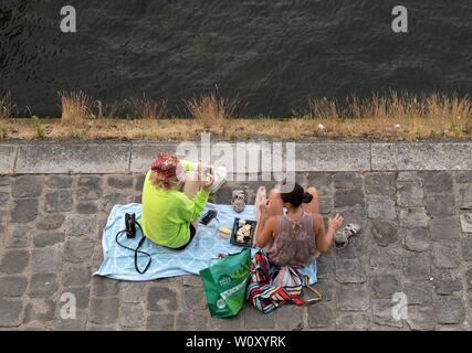 Paris, France. 27th June, 2019. People rest at the riverside of Seine in Paris, France, June 27, 2019. The national weather center, Meteo France, on Thursday warned of 'exceptional heat peak' on June 28, placing 4 southern regions on red alert, the highest alert on the agency's four-scale system, and urges residents to be extremely vigilant. While 76 other regions, except Brittany, in northwest France, remain on orange alert till next week. Credit: Jack Chan/Xinhua/Alamy Live News Stock Photo