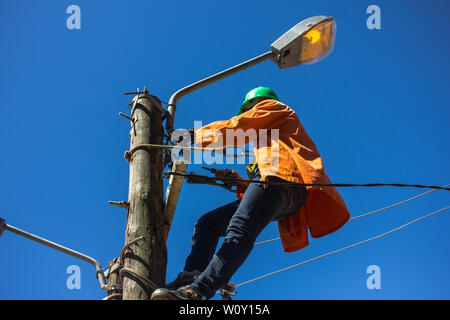 Electrician doing maintenance of street lamps in Africa. Stock Photo