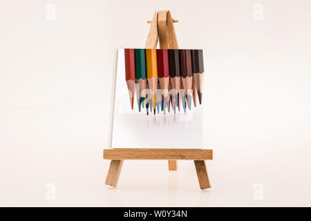 Color pencils  on notepaper on  painting tripodon white background Stock Photo