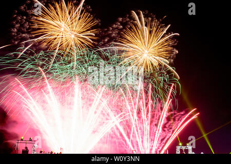 Colorful fireworks against a black night sky.Fireworks for new year. Beautiful colorful fireworks display on the urban lake for celebration on dark ni Stock Photo