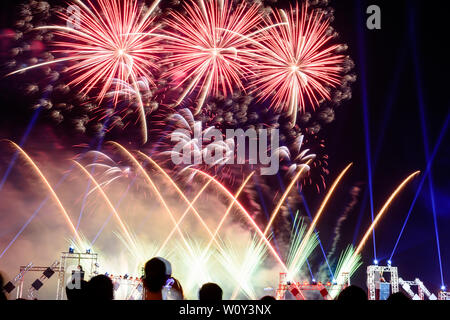 Colorful fireworks against a black night sky.Fireworks for new year. Beautiful colorful fireworks display on the urban lake for celebration on dark ni Stock Photo