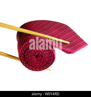 Wooden chopsticks holding red male necktie rolled as sushi and isolated on white background, business fashion concept Stock Photo