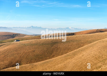 Plateau of Lessinia, Regional Natural Park of Lessinia, Veneto, Verona, Italy. In the background the Italian Alps (Adamello, Presanella and Brenta) Stock Photo