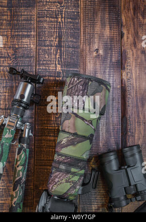 Equipment for the observation and photography of wild fauna on a rustic wooden table Stock Photo