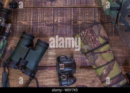 Equipment for the observation and photography of wild fauna on a rustic wooden table Stock Photo