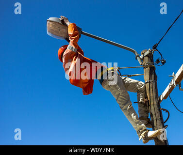 Electrician doing maintenance of street lamps in Africa. Stock Photo