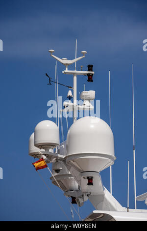 Detail of a luxury white yacht with navigation equipment, radar and antennas on blue sky, superstructure Stock Photo