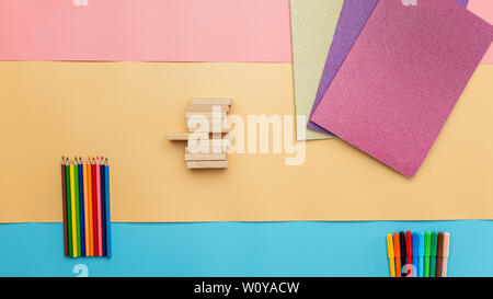 Back to school conceptual photo with notebooks, color pencils and wooden blocks. Top view. Stock Photo