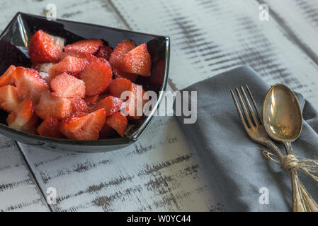 Strawberries with sugar laid out on a white wooden background Stock Photo