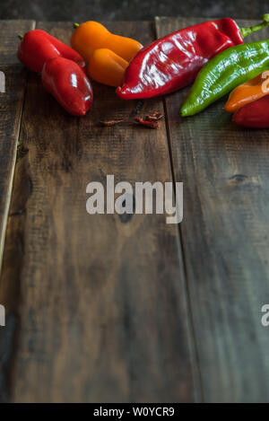 Peppers of various colors on a wood background Stock Photo