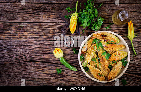 Fried zucchini flowers stuffed with ricotta and green herbs. Vegan food. Italian cuisine. Top view Stock Photo