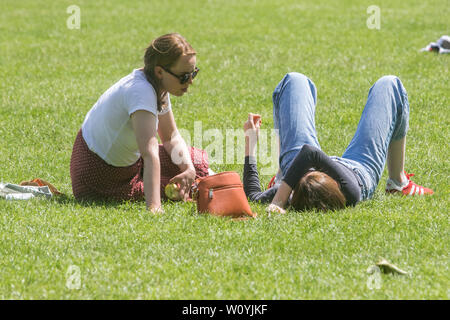 people enjoy the summer sunshine on a hot day in London as warm temperatures sweep from Continental Europe as  European capital cities are experiencing a heatwave and high  record weather for this time of the year. Stock Photo