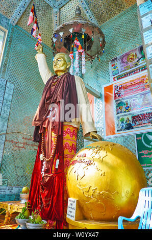 POPA, MYANMAR - FEBRUARY 26, 2018: The Nat Shrine with a statue of Spirit Deity at the golden globe, the site situated on the slope of Popa Taung Kala Stock Photo