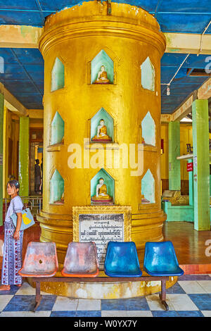 POPA, MYANMAR - FEBRUARY 26, 2018: The entrance hall and shrine of Popa Taung Kalat monastery with golden column, decorated with images of Buddha in s Stock Photo