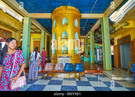 POPA, MYANMAR - FEBRUARY 26, 2018: The shrine of Popa Taung Kalat monastery, located at its entrance and decorated with large golden column with Buddh Stock Photo