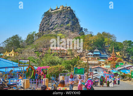 POPA, MYANMAR - FEBRUARY 26, 2018:  The numerous pilgrims visit temples of Popa town and its main landmark - Taung Kalat monastery, located on the roc Stock Photo