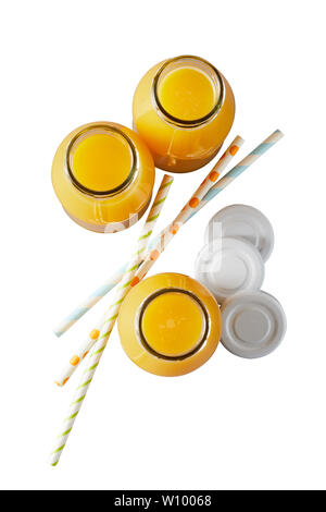 Three recyclable glass bottles of freshly squeezed orange juice rich in vitamin C viewed top down with lids and straws isolated on white Stock Photo