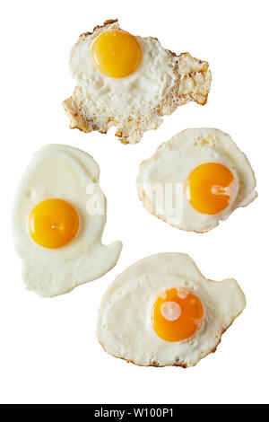 Four fried eggs ranging from soft to crispy with bright yellow yolks isolated on white viewed from above for food placement or menu advertising Stock Photo