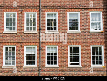 Eight windows with white sash and frame on a red brick wall Georgian British style Stock Photo