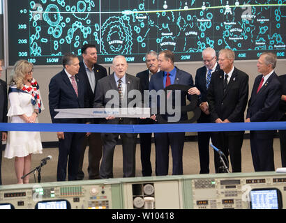 Retired NASA flight director Gene Kranz uses oversized scissors to cut the ceremonial ribbon during dedication of the newly restored Mission Control Center at NASA's Johnson Space Center near Houston, Texas. Kranz was one of the driving forces behind the historically accurate restoration of the control center, where he managed the ground engineers during the first manned moon landing in July 1969, in time for the 50th anniversary of the event. Stock Photo