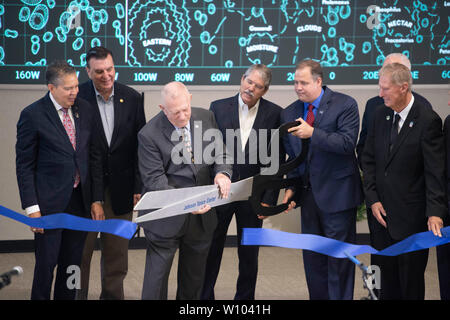 Retired NASA flight director Gene Kranz uses oversized scissors to cut the ceremonial ribbon during dedication of the newly restored Mission Control Center at NASA's Johnson Space Center near Houston, Texas. Kranz was one of the driving forces behind the historically accurate restoration of the control center, where he managed the ground engineers during the first manned moon landing in July 1969, in time for the 50th anniversary of the event. Stock Photo