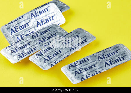 Chernivtsi, Ukraine - July 24, 2018: AEvit - vitamins. Photo of sealed blisters with pills on yellow background. Stock Photo