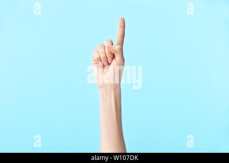 human hand showing number one, isolated on blue background Stock Photo