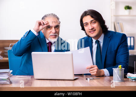 Young and old employees working together in the office Stock Photo