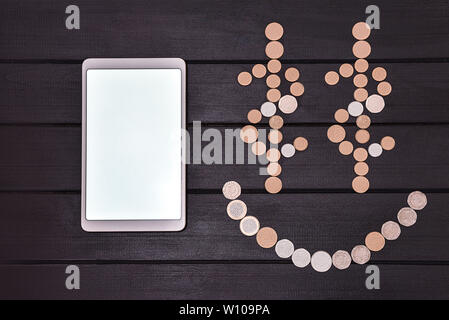 Financial success concept. Smartphone and Coins Formed A Smiley Face emoji on the table. Lucky day. success business. free copyspace Stock Photo
