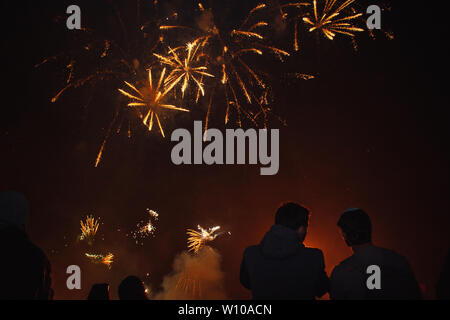 Silhouettes of crowds of people who are watching the fireworks