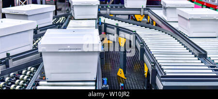 White plastic box on conveyor belt.parcels transportation system concept Stock Photo