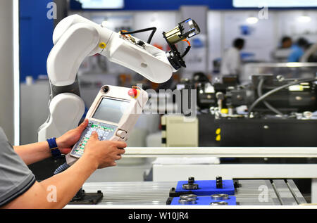 Engineer check and control automation Robot arm machine for Automotive bearings packing process in factory. Stock Photo