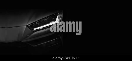 Silhouette of black super car with LED headlights on black background,copy space