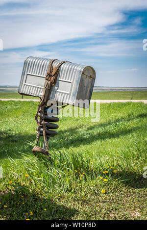 A row of three old metal farmers mailboxes on the prairies in rural Saskatchewan, Canada Stock Photo