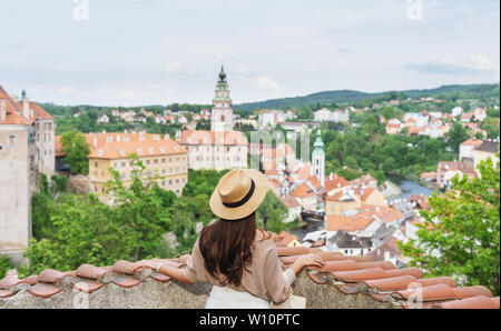 Young traveler woman in hat looking at city view of Cesky Krumlov, Czech Republic in summer. Traveling europe in summer Stock Photo