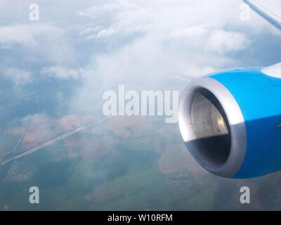 Clouds,roads and fields, engine and wing of plane. Aerial view from plane illuminator. Stock Photo