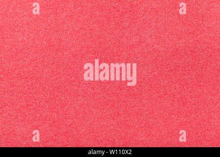 Light red matte background of suede fabric, closeup. Velvet texture of seamless pink woolen felt. Stock Photo