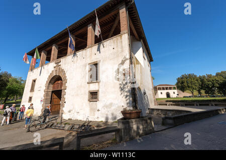 Ancient palace, a tourist information point in downtown of Lucca, Tuscany, Italy, Europe. Group of tourists is entering to ask about the city Stock Photo