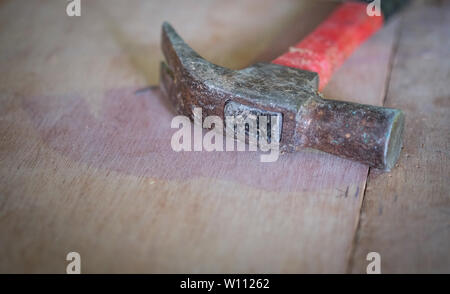 Old hammer head on wooden table, selective soft focus. Stock Photo