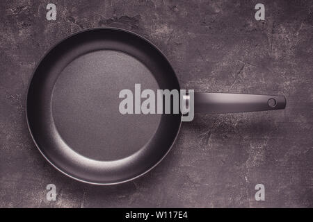 Kintchen Frying Pan on Dark Surface. Empty Culinary Background. Stock Photo